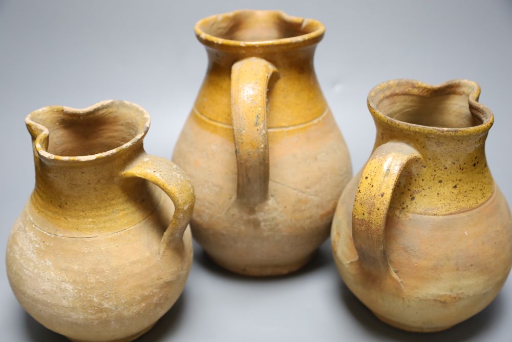 A group of three late 19th century part glazed Verwood pottery pitchers, tallest 25cm